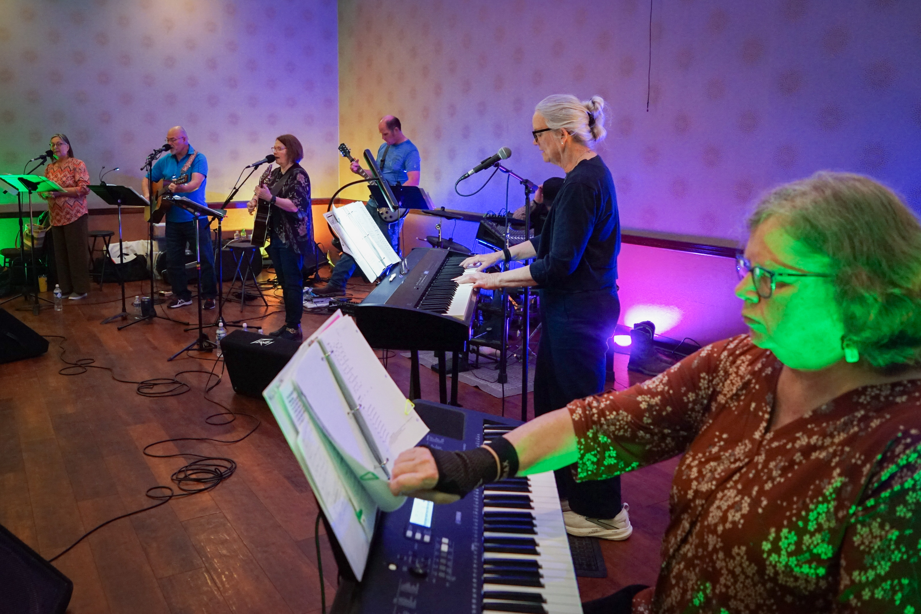 Worship band performing under colorful stage lighting