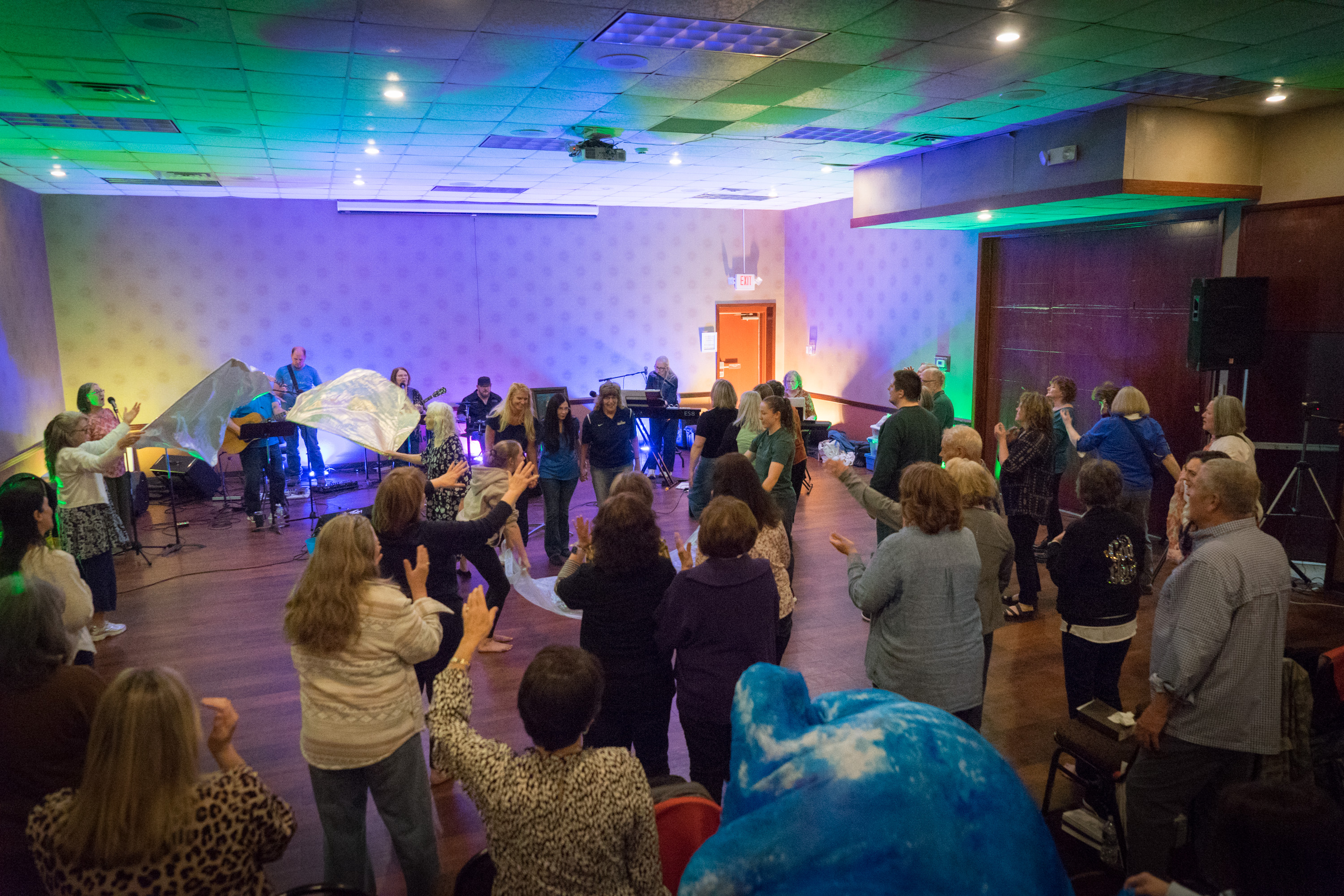Worship gathering with praise flags and the band leading