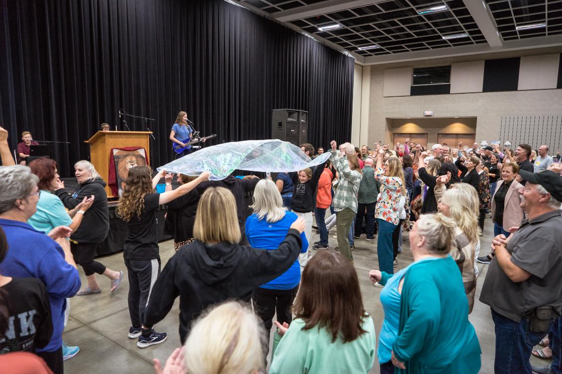 Congregation gathered in joyful worship with praise flags