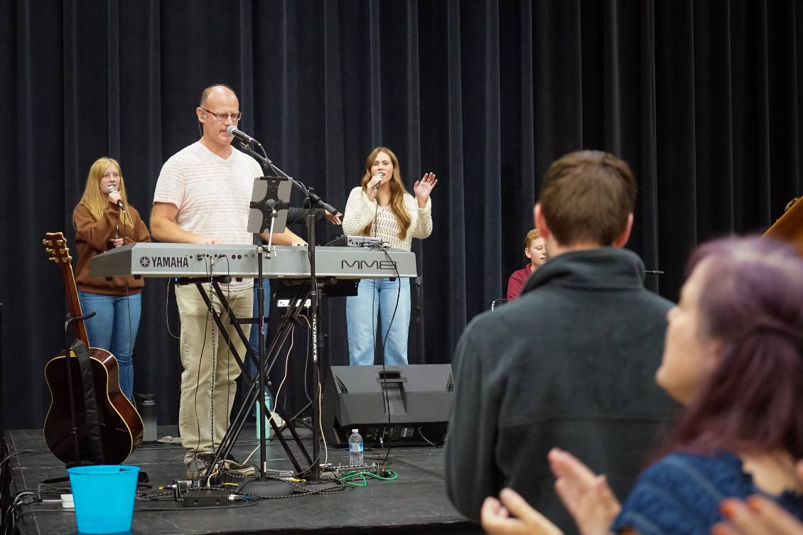 Worship team leading with keyboard and vocals on stage